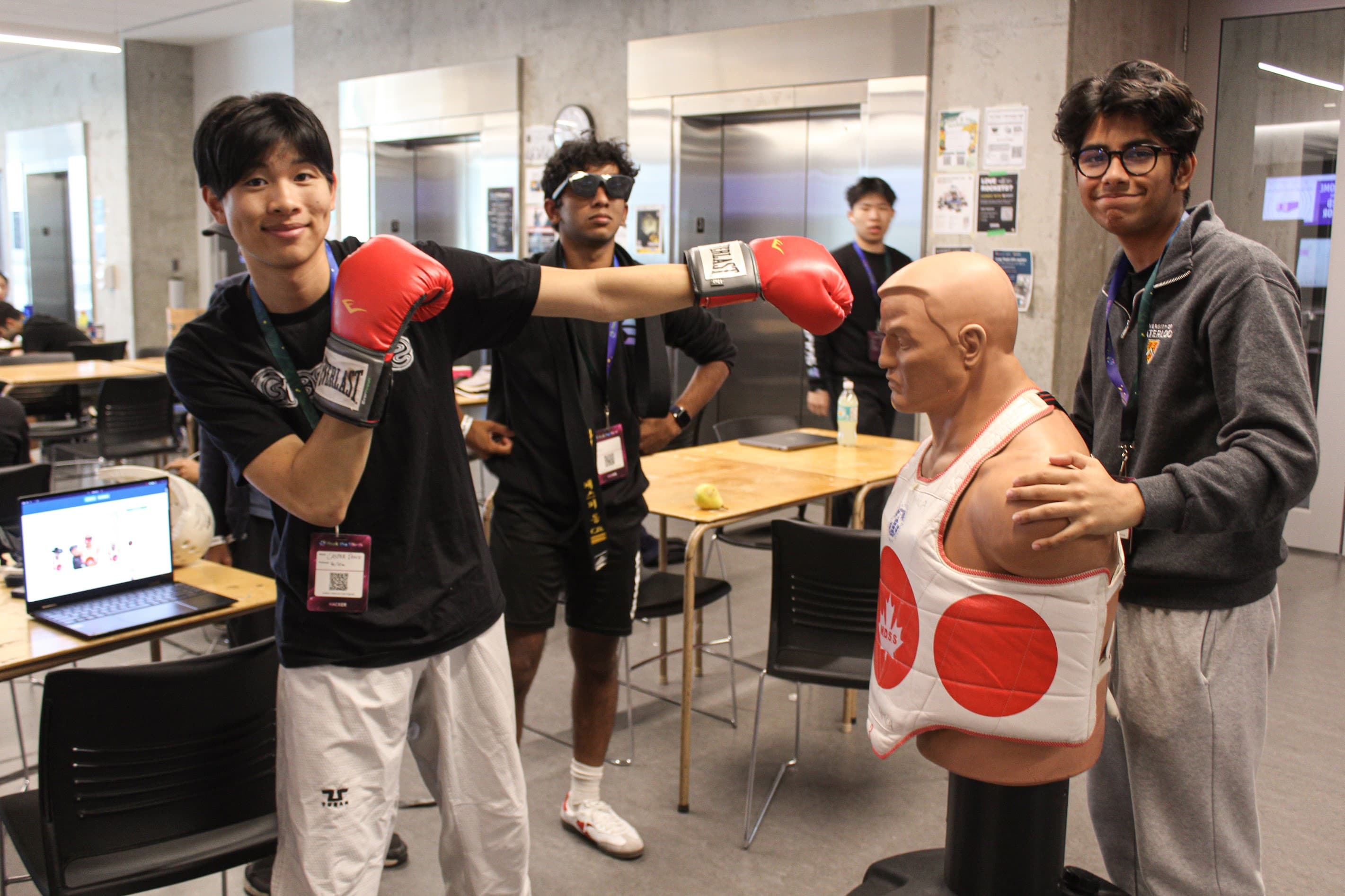 Hack the North 2025 project team with a boxing training dummy